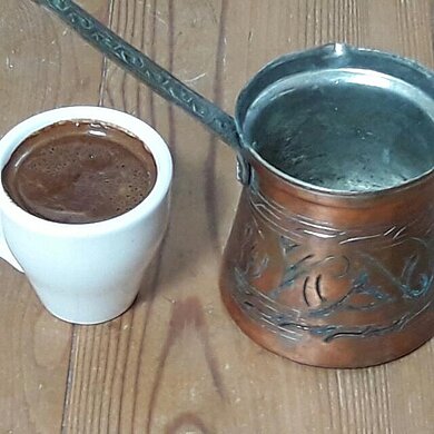 Kleine Metallkanne und kleine Tasse mit türkischem Mokka. 