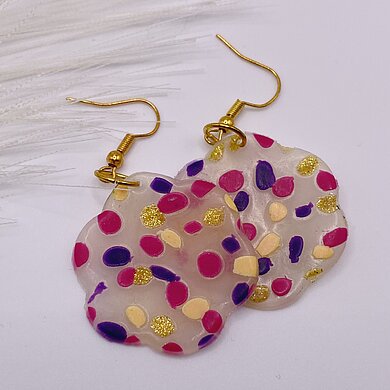 Bunte Ohrringe aus Polymer Clay mit pinken, violetten, gelben und goldenen Punkten.