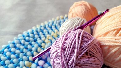 Bunte Wollknäuel, Häkelnadel.
